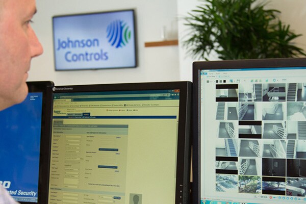 A security officer watching surveillance footage on a monitor